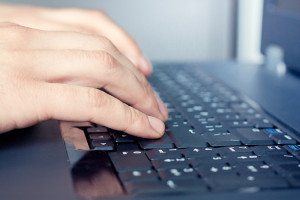 Hand over keyboard of the laptop in server room