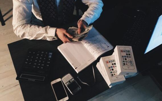 Person counting money at desk